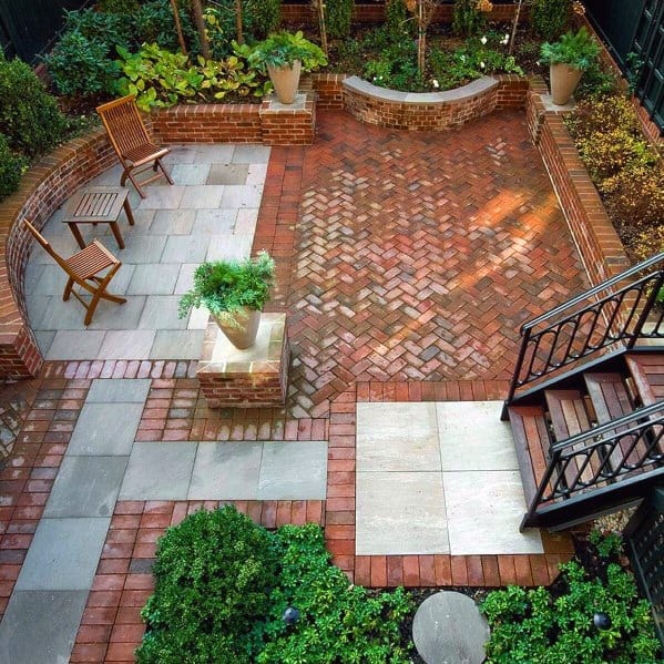 Brick patio with stone, plants, and wooden chairs viewed from above