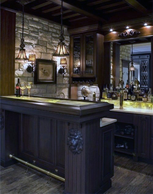 Cozy bar with dark wood, stone wall, hanging lights, and various bottles on display