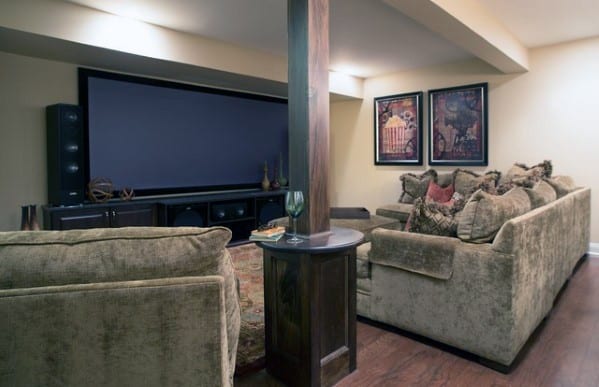 Cozy home basement theater with plush sofas, a large screen, and wooden accents.