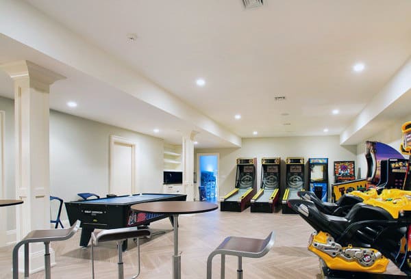 Game room with arcade machines, air hockey table, and seating area featuring bright lighting and wooden floor