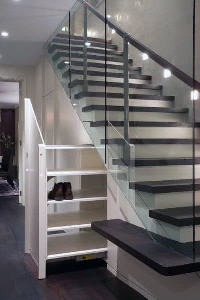 Staircase with glass railing and pull-out shoe storage underneath in a modern interior.