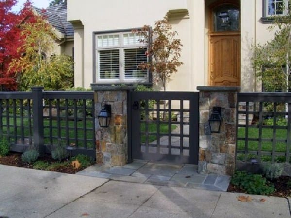 black lattice front yard with stone pillars and lights 