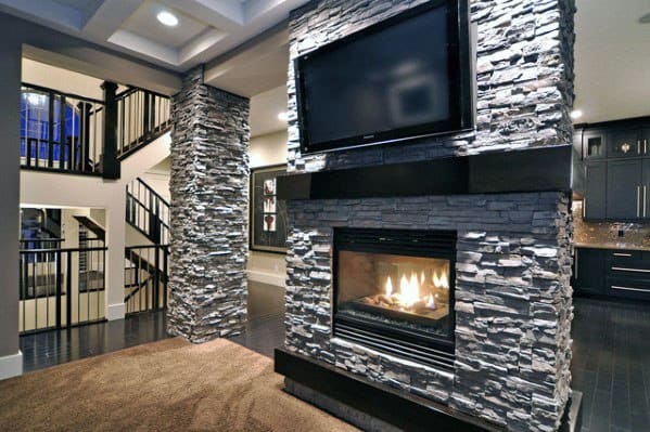Modern stacked stone fireplace with a built-in TV, creating a sleek focal point in a stylish living area