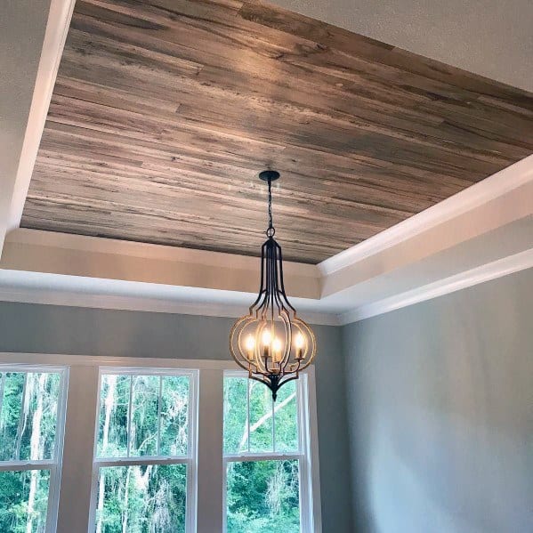 Dining room with recessed wood plank ceiling and modern pendant light.