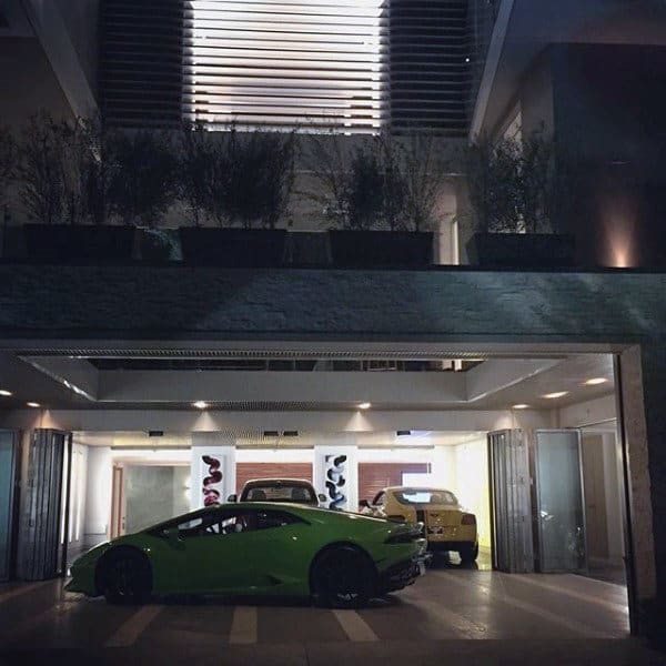 A sleek underground garage featuring luxury cars, modern lighting, and a sophisticated design seamlessly integrated with the home above.