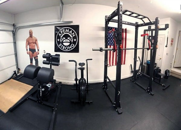 Garage gym with squat rack, rowing machine, lifting platform, and GHD machine.