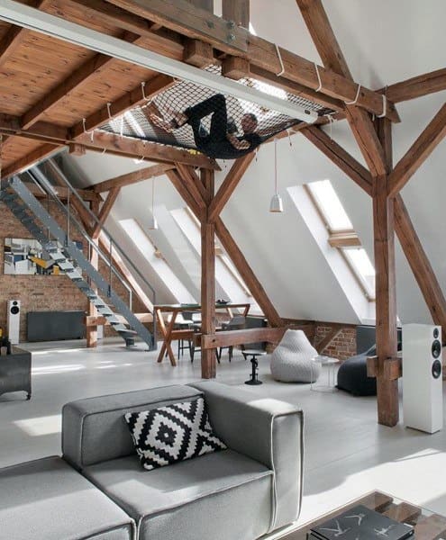 Loft-style living space with a suspended net hammock, exposed beams, and modern furniture.
