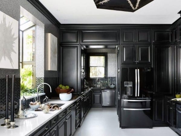 Elegant black kitchen cabinets with high ceilings, black appliances, and white countertops.