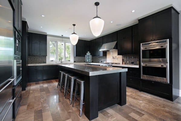 Spacious black kitchen with a large island, pendant lighting, and dark cabinetry.