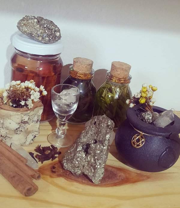 A mystical display with pyrite crystals, corked jars of herbs, and a small cauldron, designed to promote positive energy in your space.
