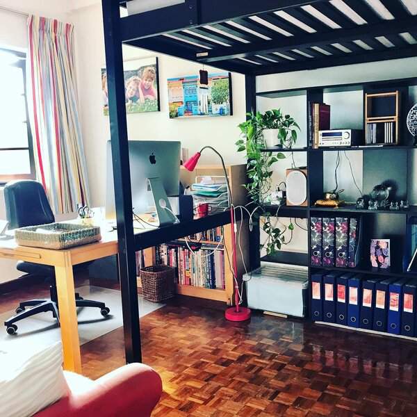 A small workspace with smart vertical shelving, a colorful desk lamp, and a plant to boost energy and create a productive environment.