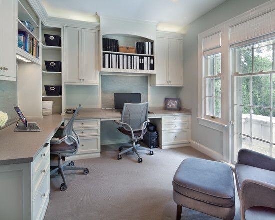 Home office with a built-in desk, chairs, and shelving; a computer monitor on one desk; large window on the right