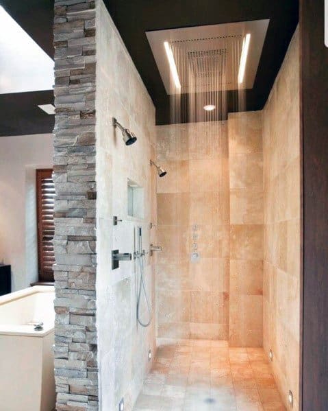 Elegant shower featuring a waterfall showerhead with recessed lighting, complemented by stone accents for a luxurious touch