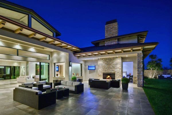 Modern patio with sofas, fireplace, and ambient lighting at night