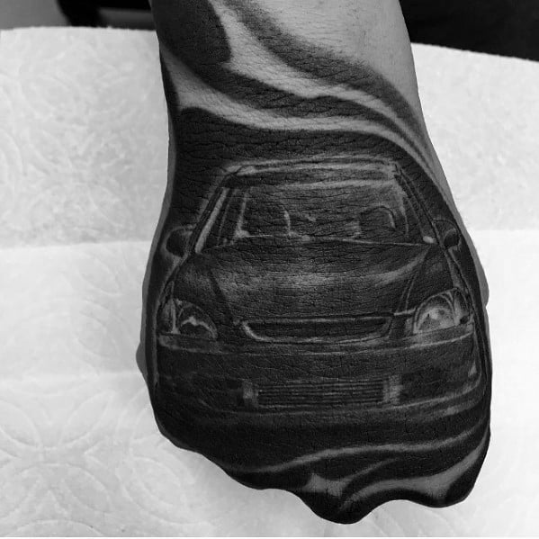 Realistic Honda Civic tattoo on a man's hand, featuring a detailed front view with bold shading and a dynamic background effect.