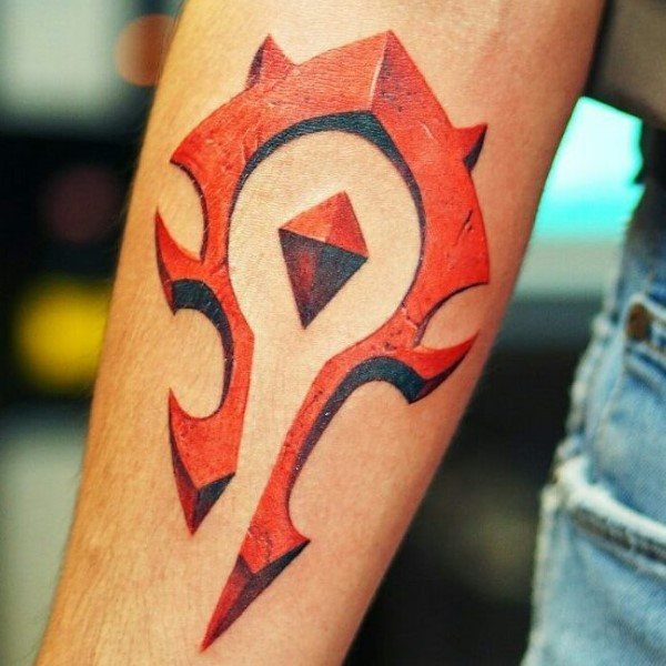 Bold red and black tattoo of the Horde emblem from World of Warcraft, featuring a cracked stone texture and sharp edges, inked on the forearm.
