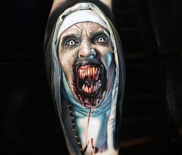 Realistic color tattoo of Valak from *The Nun*, featuring glowing eyes, sharp fangs, and bloodied details for a terrifying and haunting horror effect.