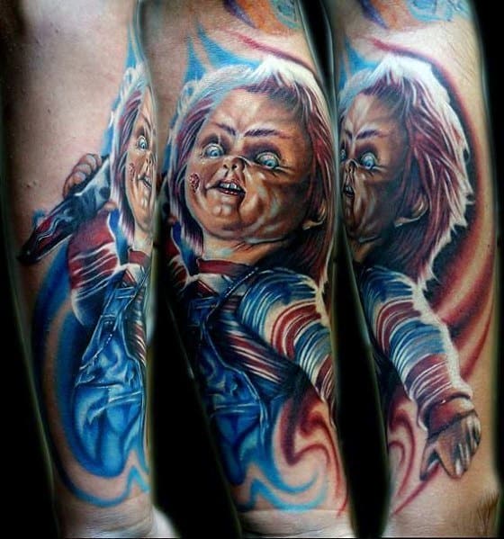 Vibrant color tattoo of Chucky from *Child’s Play*, featuring his sinister grin, glowing blue eyes, and dynamic shading for a lifelike horror effect.