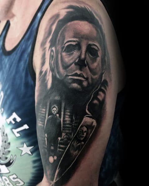 Black and grey tattoo of Michael Myers from *Halloween*, featuring his eerie mask, a large knife, and iconic horror imagery for a chilling effect.
