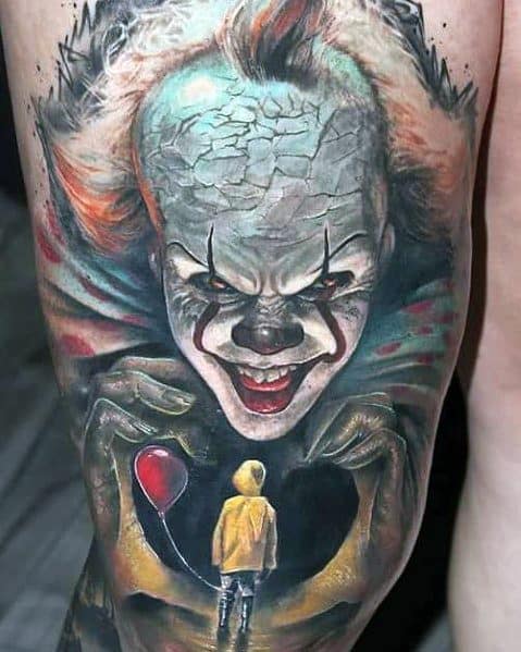 Realistic color tattoo of Pennywise from *IT*, featuring his sinister grin, cracked forehead, and Georgie holding a red balloon for a haunting effect.