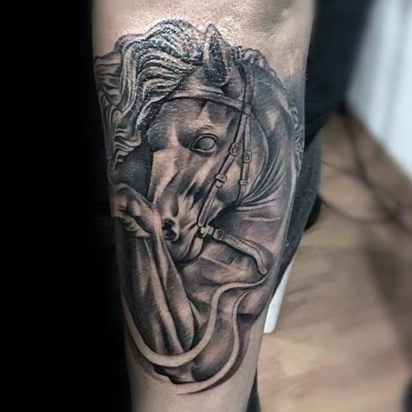 Detailed black and grey horse tattoo on upper arm, featuring strong shading and flowing mane with reins in motion