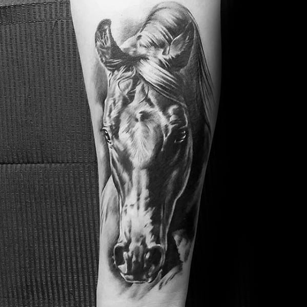 Hyper-realistic black and grey tattoo of a horse's face on the forearm, featuring detailed shading and lifelike expression