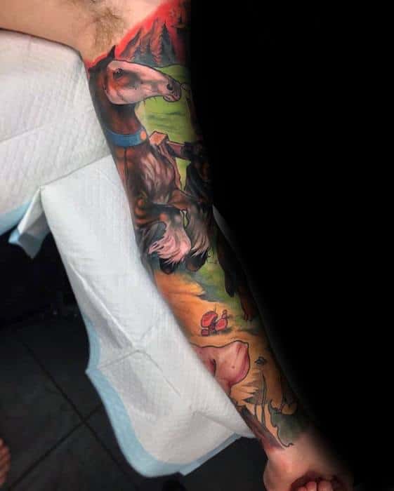 Vibrant full sleeve tattoo of a horse in a colorful nature scene with mountains, trees, and a playful forest floor design