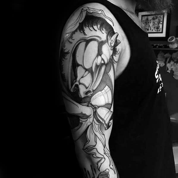 Stylized black and grey horse tattoo on the upper arm with bold lines, abstract shading, and flowing dynamic elements