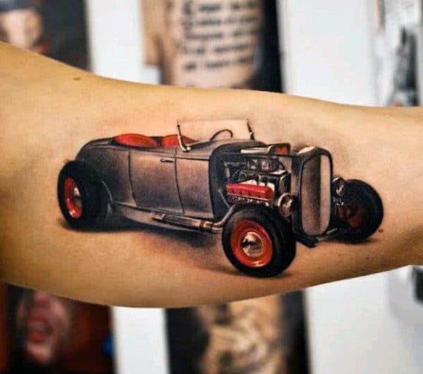 A tattoo of a vintage hot rod car in red and gray ink on an upper arm