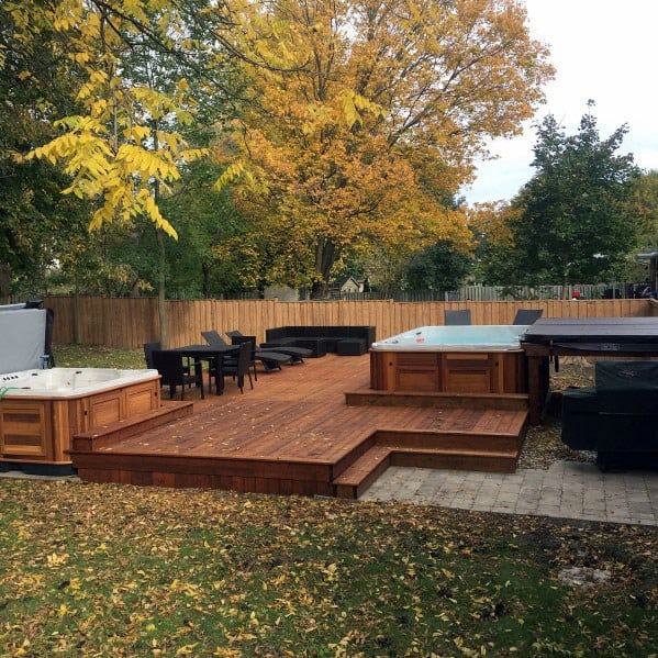 wood deck two hot tubs black wicker table chairs sofa and sun loungers