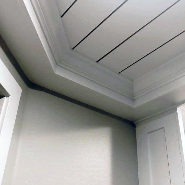 Tray ceiling with recessed lighting in a light-colored room