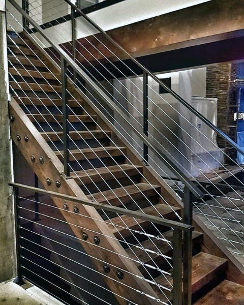 Modern staircase featuring wooden steps and sleek metal cables in an industrial-style interior