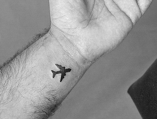 Tattoo of an airplane on a person's wrist
