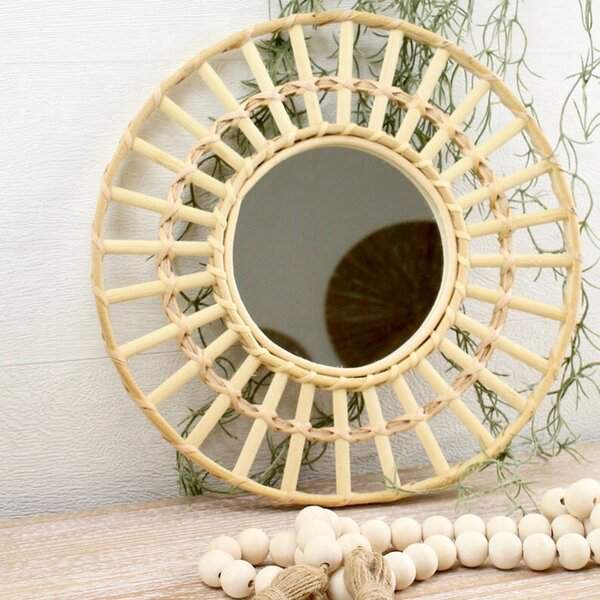 Woven rattan mirror with an airy, handcrafted design, styled with wooden beads and greenery for a Scandi-boho aesthetic.