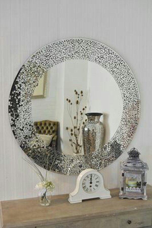 Round mirror with a mosaic frame reflecting a chic interior, styled with vintage decor and neutral tones for a sophisticated look.