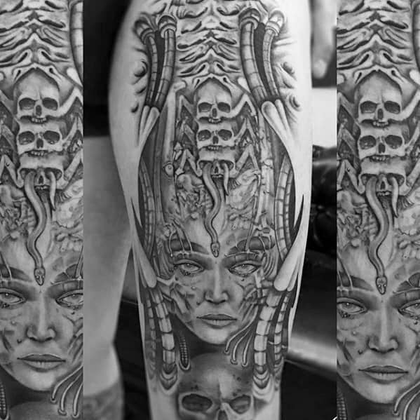 HR Giger-style tattoo featuring a biomechanical female face fused with skulls, tubing, and intricate alien-mechanical elements.