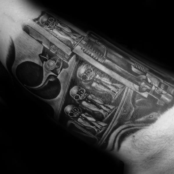 HR Giger-inspired tattoo showing skeletal alien figures enclosed in a mechanical chamber with dark, biomechanical detailing.