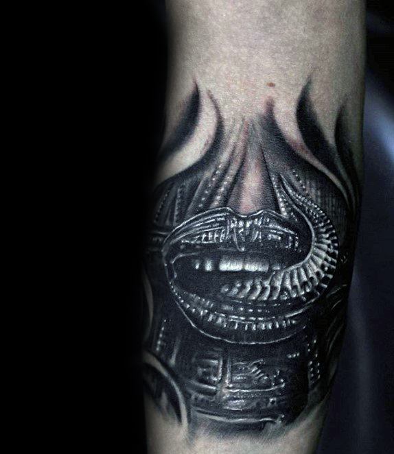 HR Giger-inspired tattoo showing a biomechanical mouth design with sharp detailing, dark shadows, and alien-mechanical textures.