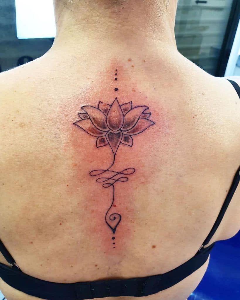 Unalome tattoo with a lotus on the upper back, symbolizing spiritual enlightenment, resilience, and the journey to inner peace and growth.