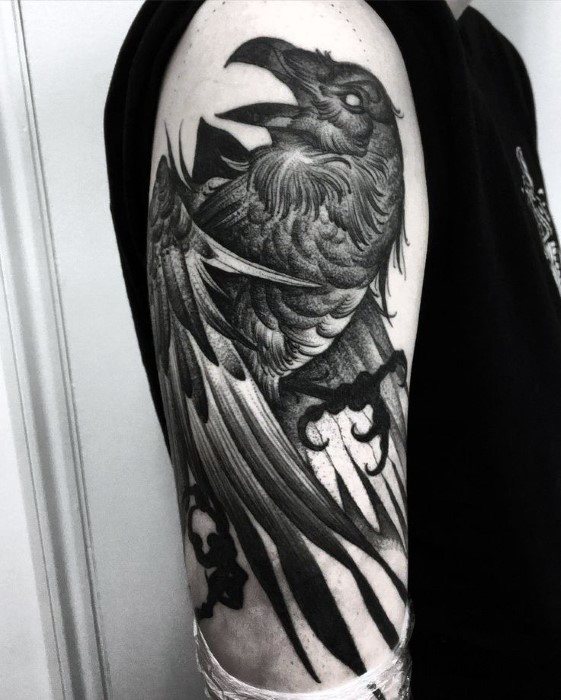 Striking black and grey tattoo of a raven in motion, inked on the upper arm with fine linework and bold shading.