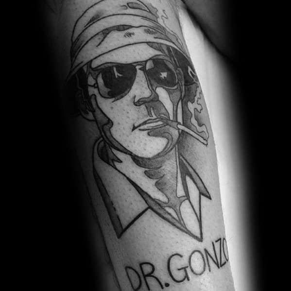 Black and white Hunter S. Thompson tattoo featuring a stylized portrait with aviator glasses, a bucket hat, a cigarette, and "Dr. Gonzo" text below.