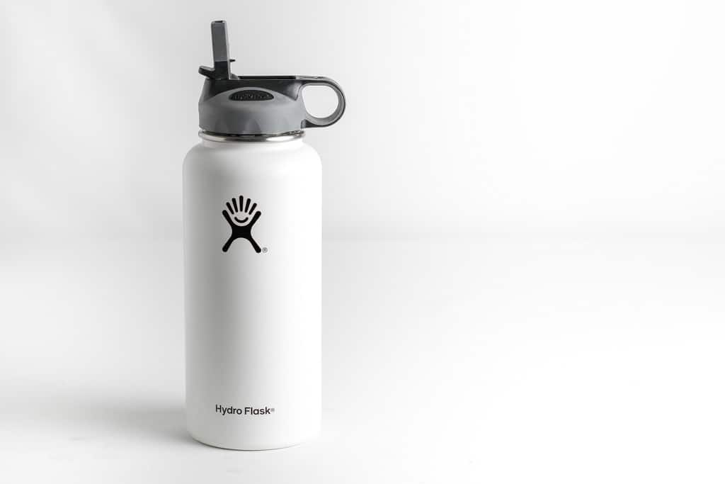 white hydroflask with company logo facing camera with white floor and white background