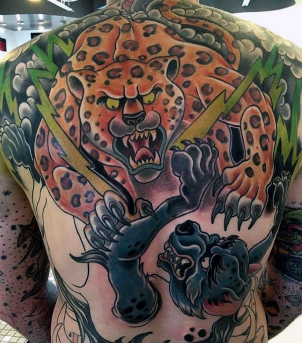 Full back tattoo featuring a fierce battle between a spotted jaguar and a black panther, with vivid lightning bolts and bold traditional colors.