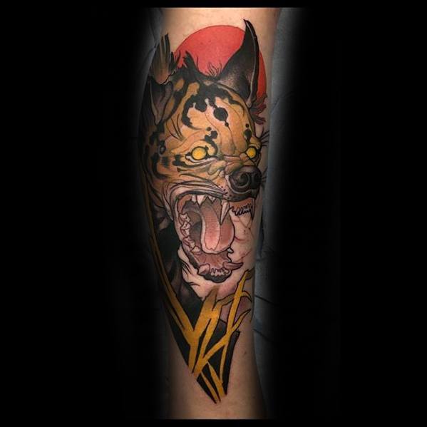 Bold neo-traditional hyena tattoo with glowing yellow eyes, sharp fangs, a red sun backdrop, and stylized geometric accents for dramatic effect.