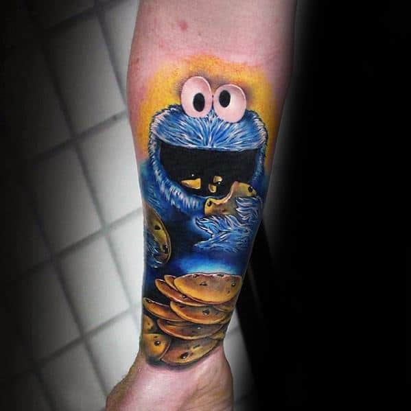 Realistic Cookie Monster tattoo on forearm with bright yellow background, happily surrounded by a large stack of chocolate chip cookies.