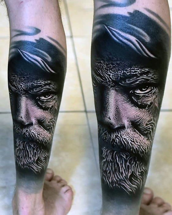 Tattoo of a detailed, realistic bearded man's face on both legs