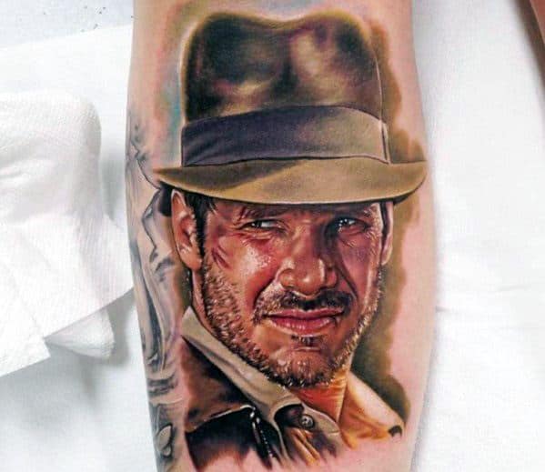 Highly detailed Indiana Jones tattoo in color, showcasing his rugged look, iconic fedora, and adventurous expression.