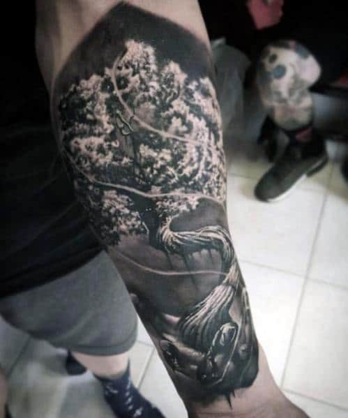Black and grey realism tattoo of a majestic tree with detailed branches, roots, and a swing, creating a surreal and atmospheric design.