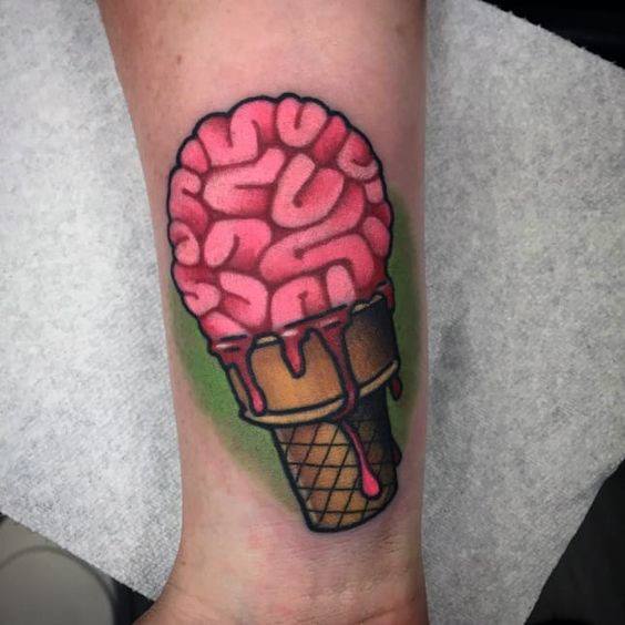 Tattoo of a melting pink brain in an ice cream cone, blending horror and surrealism with bold outlines and vibrant shading.