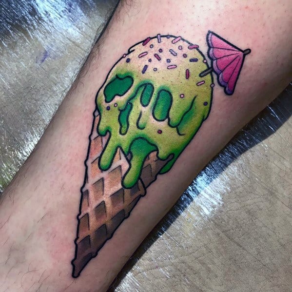 Tattoo of a melting green ice cream cone with sprinkles, a pink cocktail umbrella, and bold outlines, blending playful and surreal elements.